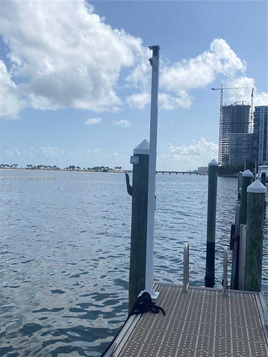 A wooden dock with white pilings extends into a body of water under a blue sky — 1901 Brickell Ave Slip 29A, Miami FL 33129, MIAMI, FL