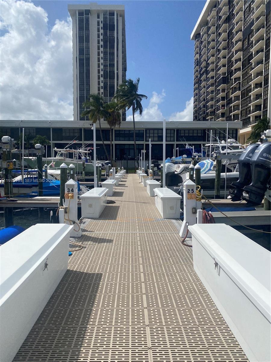 A view down a boat dock with numbered pilings and white storage boxes between slips — 1901 Brickell Ave Slip 29A, Miami FL 33129, MIAMI, FL