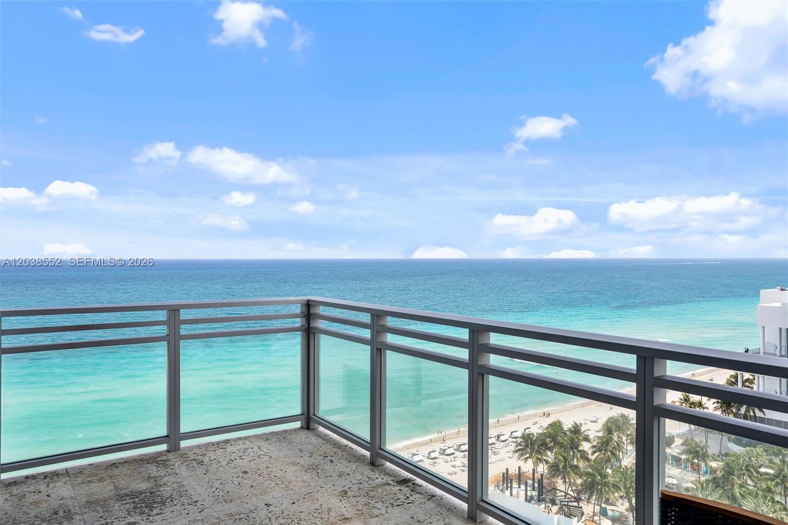 A balcony with a glass railing overlooks the ocean and a sandy beach — 3535 S Ocean Dr # 1703, Hollywood FL 33019, HOLLYWOOD, FL