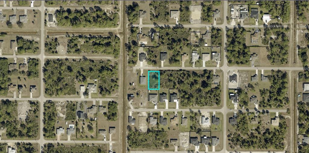 An aerial view shows a vacant, rectangular residential lot highlighted in blue within a neighborhood — 3013 38TH STREET W, LEHIGH ACRES, FL