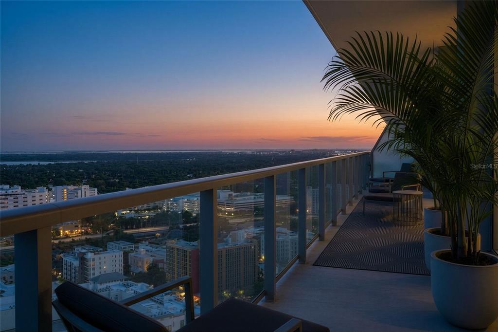 A bright, empty room with white tile floors, large windows, and a balcony overlooking water — 400 CENTRAL AVENUE UNIT 2906, ST PETERSBURG, FL