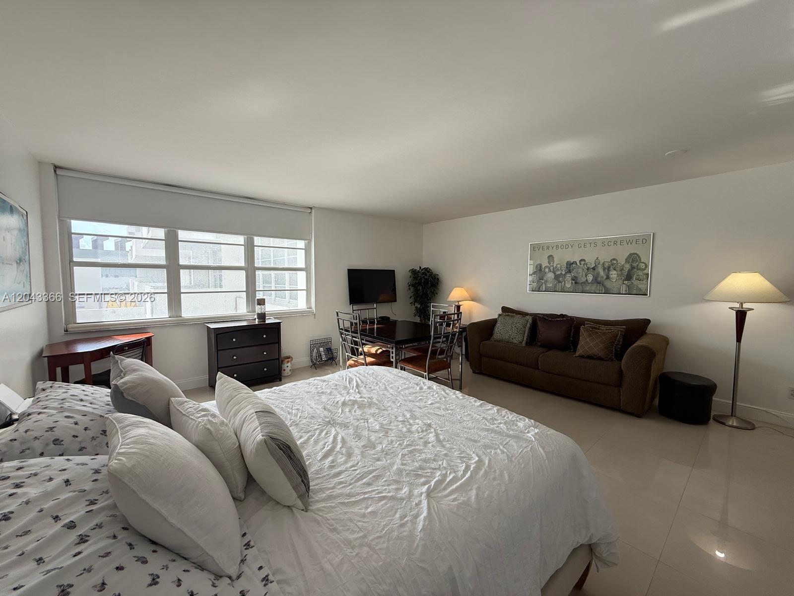 A bedroom with a large bed, a sofa, a dining table, and tile flooring — 100 Lincoln Rd # 316, Miami Beach FL 33139, MIAMI BEACH, FL