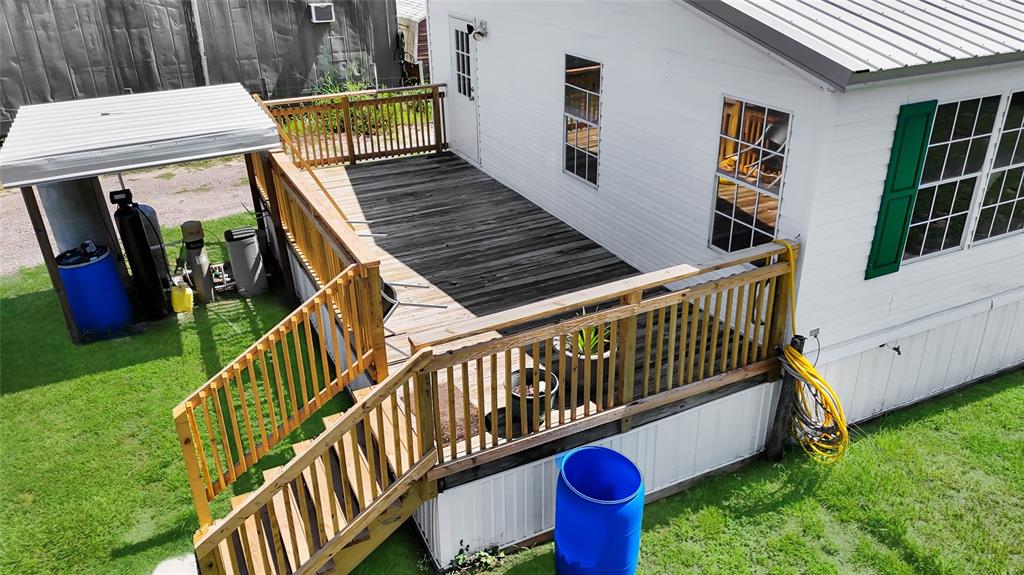 An elevated wooden deck with railings and stairs attached to the side of a house — 1725 MARKER ROAD, POLK CITY, FL