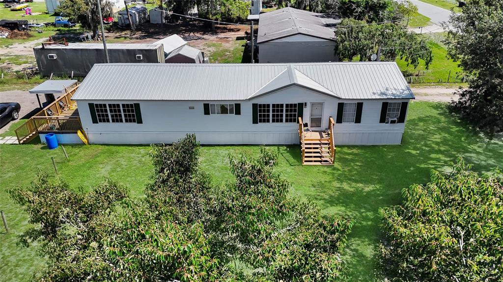 An aerial view of a white manufactured home with a metal roof and wooden decks — 1725 MARKER ROAD, POLK CITY, FL