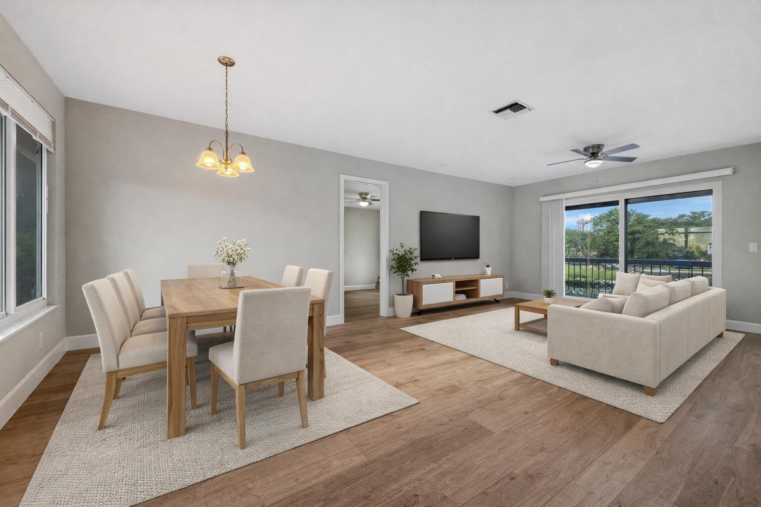 An open-concept living and dining room with light wood floors, neutral furniture, and a balcony — 13586 Sabal Palm Court # D, Delray Beach FL 33484, DELRAY BEACH, FL
