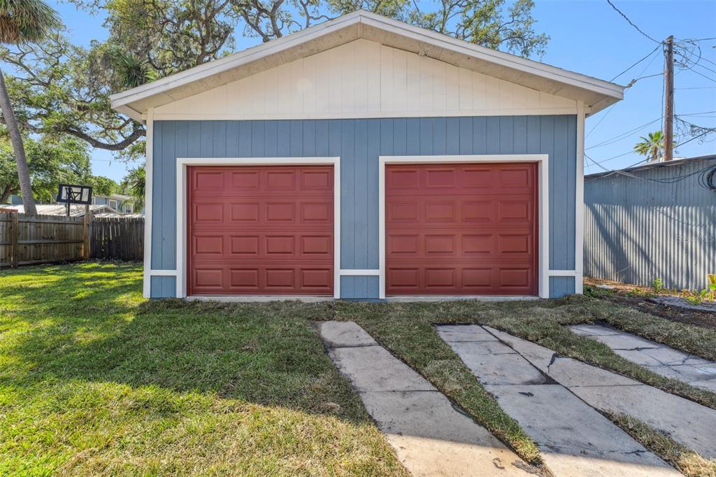 A detached garage with blue siding and two red doors sits on a grassy lot — 307 S NEWPORT #1-2 AVENUE, TAMPA, FL