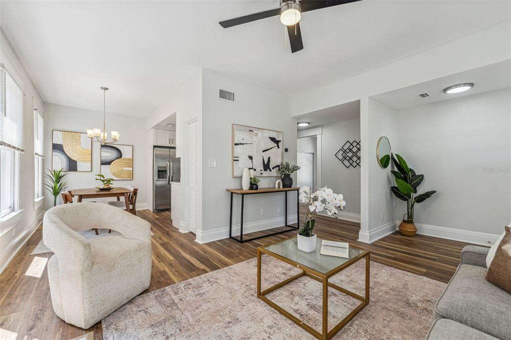 An open-concept living and dining area features wood-look flooring, neutral walls, and modern furniture — 307 S NEWPORT #1-2 AVENUE, TAMPA, FL