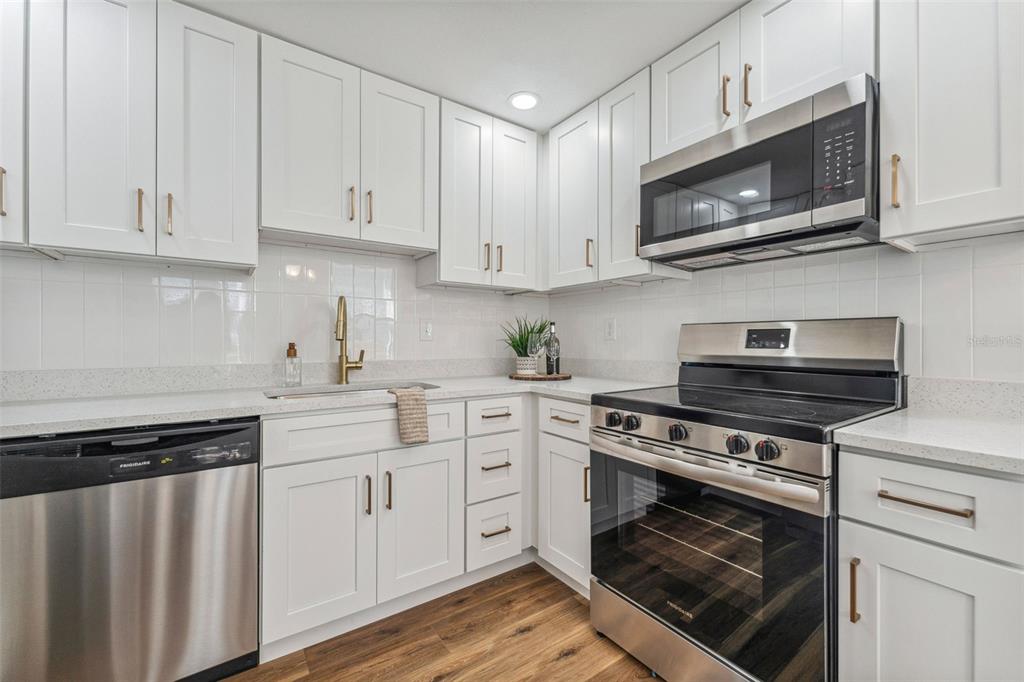 A kitchen with white cabinets, stainless steel appliances, gold hardware, and light-colored countertops — 307 S NEWPORT #1-2 AVENUE, TAMPA, FL