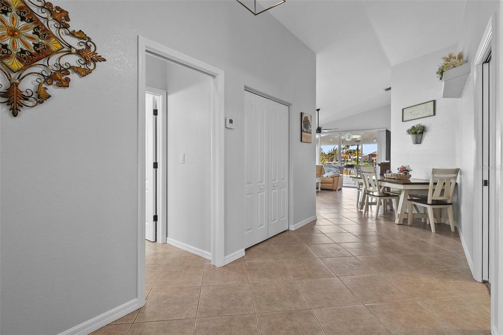 A tiled hallway leads to a dining area and living space with views of water — 12962 SW DOUG DRIVE, LAKE SUZY, FL