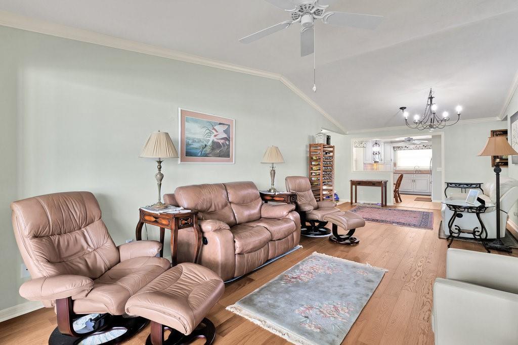 A living room with light green walls, hardwood floors, leather recliners, and a ceiling fan — VERO BEACH, FL