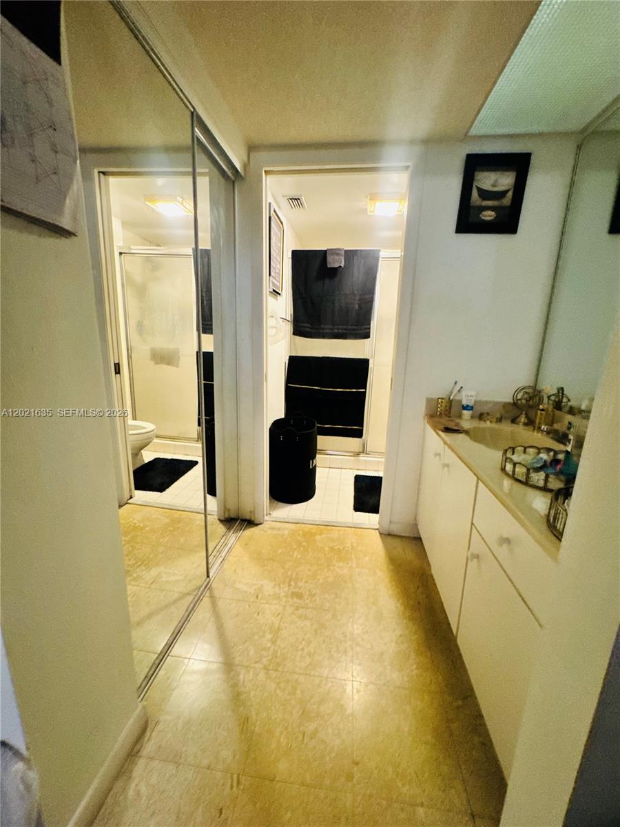 A bathroom features a vanity with a sink, mirrored closet doors, and a separate shower — 2638 SE 21st Ct # C, Homestead FL 33035, HOMESTEAD, FL