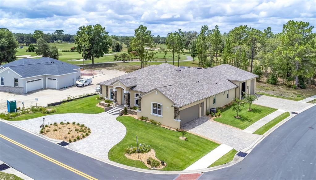 An aerial view shows a tan, single-story house with a gray roof and paved driveway — 17898 SW 72ND STREET ROAD, DUNNELLON, FL