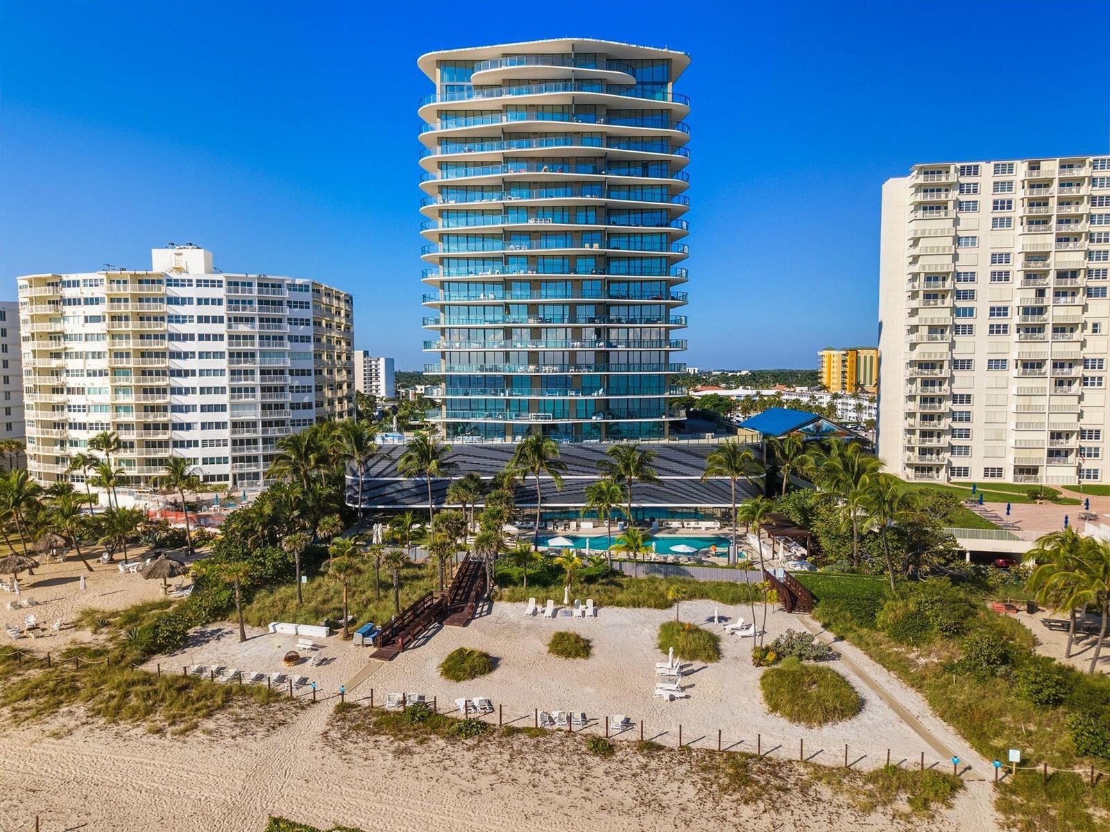 An aerial view of a modern high-rise condominium building situated on a sandy beach — 730 N Ocean Boulevard # 801, Pompano Beach FL 33062, POMPANO BEACH, FL