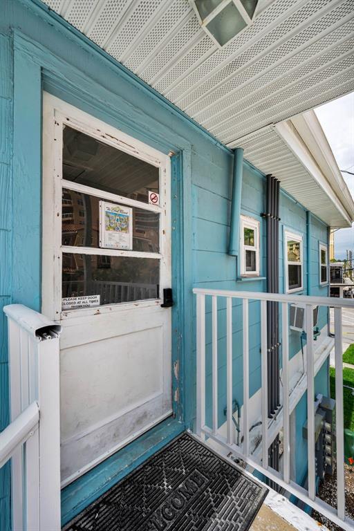 The exterior of a blue building features an outdoor staircase, two wall-mounted water heaters, and parking — 483 E SHORE DRIVE UNIT A4, CLEARWATER BEACH, FL