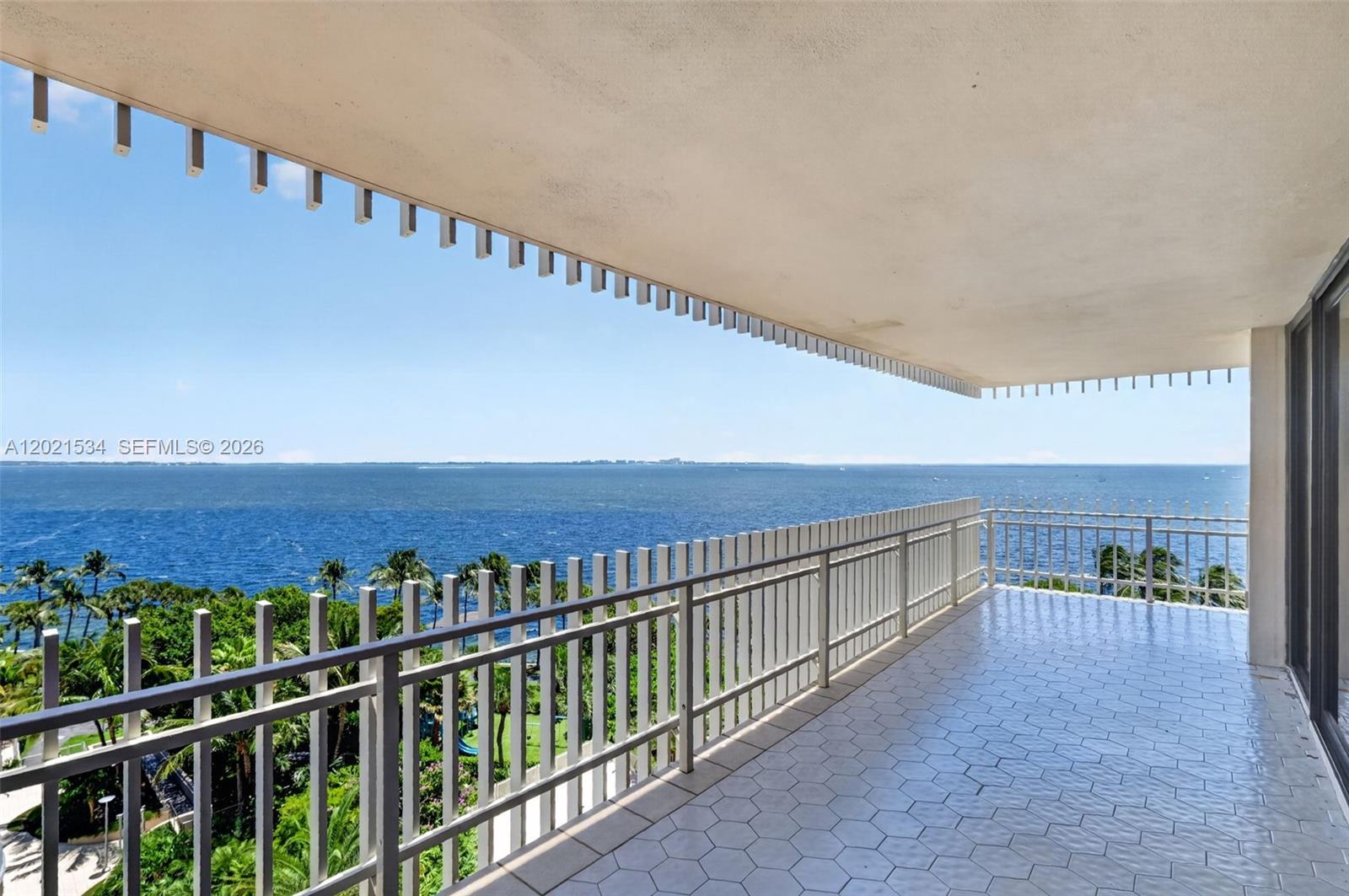 A wide balcony with white railings overlooks the ocean and palm trees — 2 Grove Isle Dr # 802, Miami FL 33133, MIAMI, FL