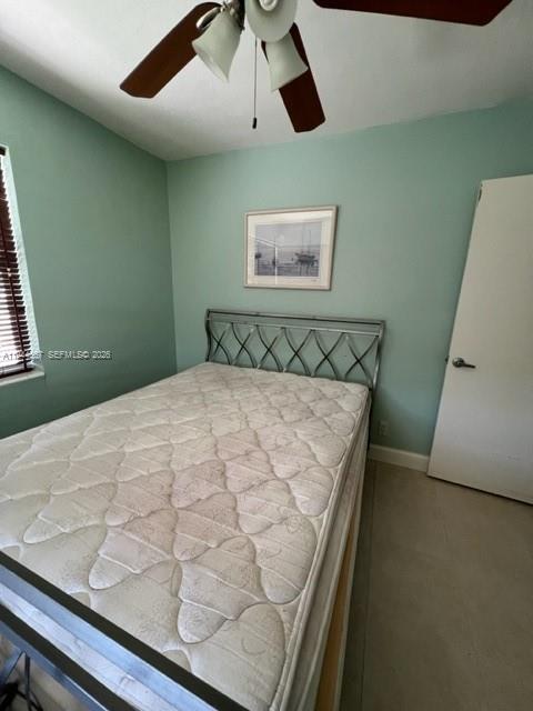 A bedroom features a metal-framed bed, a ceiling fan, and light green walls — 413 SW 2nd Ave, Dania Beach FL 33004, DANIA BEACH, FL