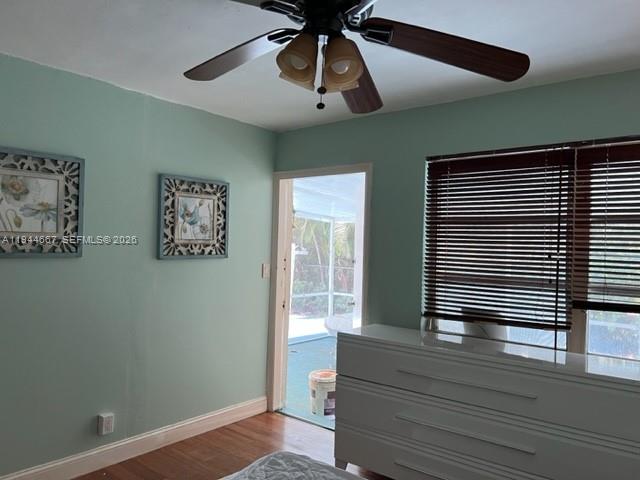 A bedroom features light green walls, a ceiling fan, a white dresser, and a doorway — 413 SW 2nd Ave, Dania Beach FL 33004, DANIA BEACH, FL