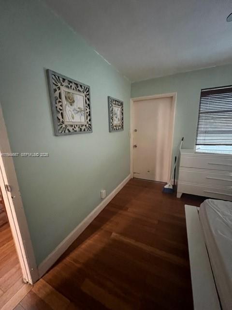 A bedroom with light green walls, wood flooring, two wall decorations, and a white dresser — 413 SW 2nd Ave, Dania Beach FL 33004, DANIA BEACH, FL