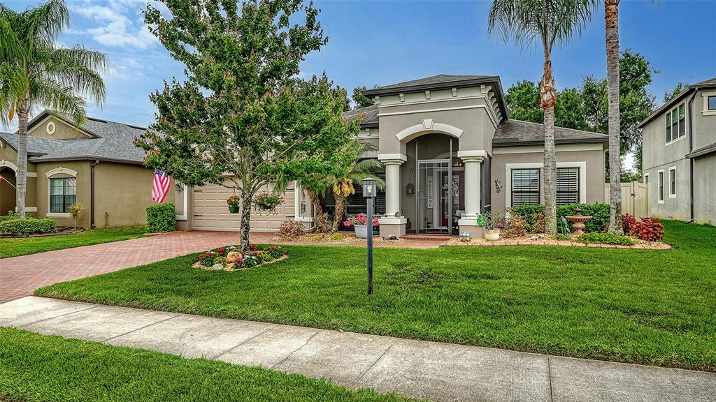 A single-story suburban house with a paved driveway, a manicured lawn, and a covered entryway — 766 129TH STREET NE, BRADENTON, FL