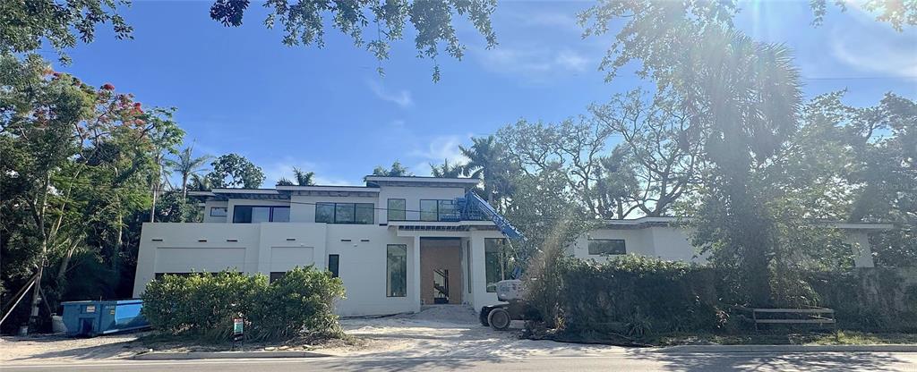 A modern two-story house under construction features white stucco walls and a blue boom lift — 2100 MCCLELLAN PARKWAY, SARASOTA, FL