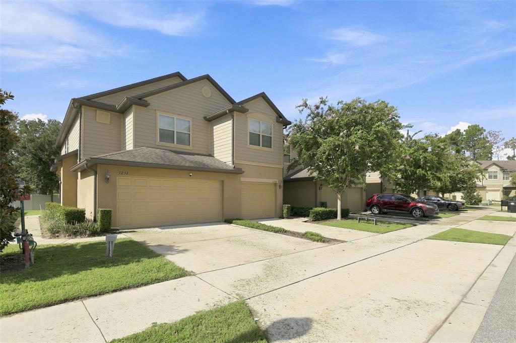 A two-story tan house with a double garage and a concrete driveway — 1236 PAVIA DRIVE, APOPKA, FL