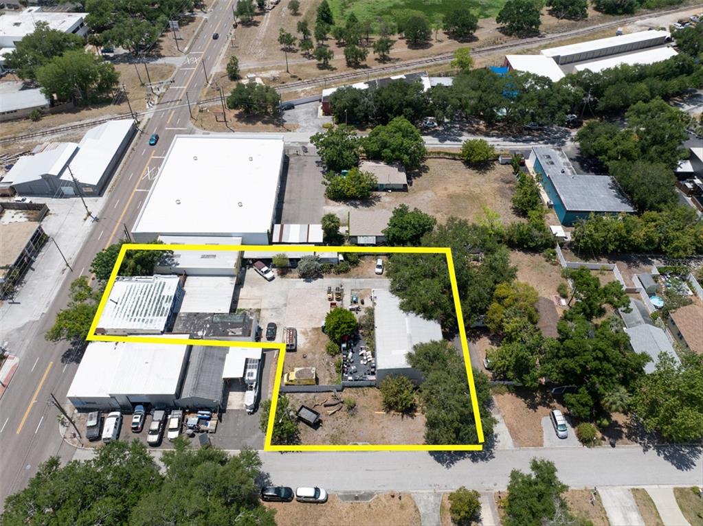 An aerial view shows a commercial property with multiple buildings and a fenced yard area — 1763 9TH AVENUE N, ST PETERSBURG, FL