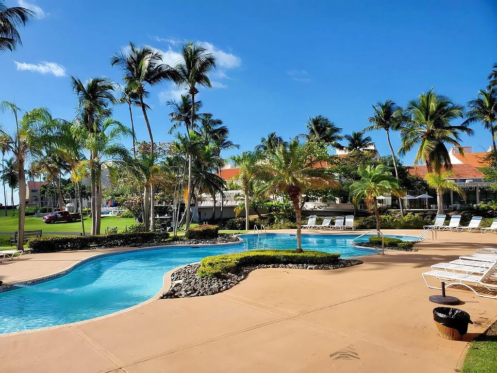 A swimming pool surrounded by palm trees and lounge chairs at a resort-style property — 170 CANDELERO DRIVE UNIT 209B, HUMACAO, PR 00791, PR