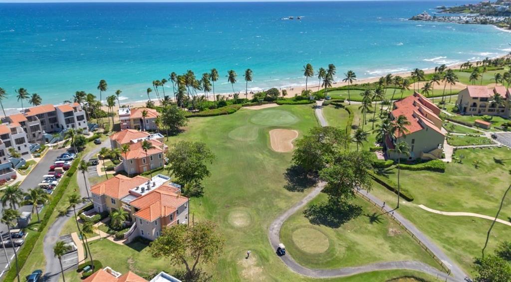 An aerial view of a golf course hole situated between residential buildings and the ocean — 170 CANDELERO DRIVE UNIT 209B, HUMACAO, PR 00791, PR