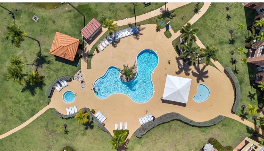 An aerial view of a community swimming pool with lounge chairs and a covered pavilion — 170 CANDELERO DRIVE UNIT 209B, HUMACAO, PR 00791, PR