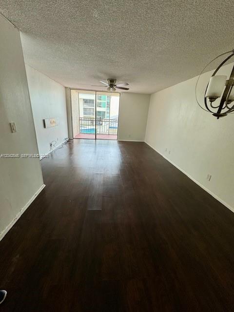 An empty living room with dark wood-look flooring, a ceiling fan, and a balcony entrance — 2029 NW 46th Ave # E202, Lauderhill FL 33313, LAUDERHILL, FL