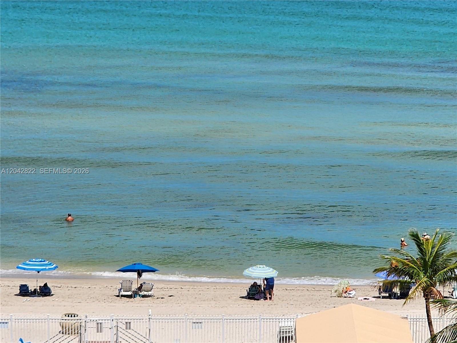An elevated view of a sandy beach with umbrellas, lounge chairs, and the ocean — 3505 S Ocean Dr # 821, Hollywood FL 33019, HOLLYWOOD, FL