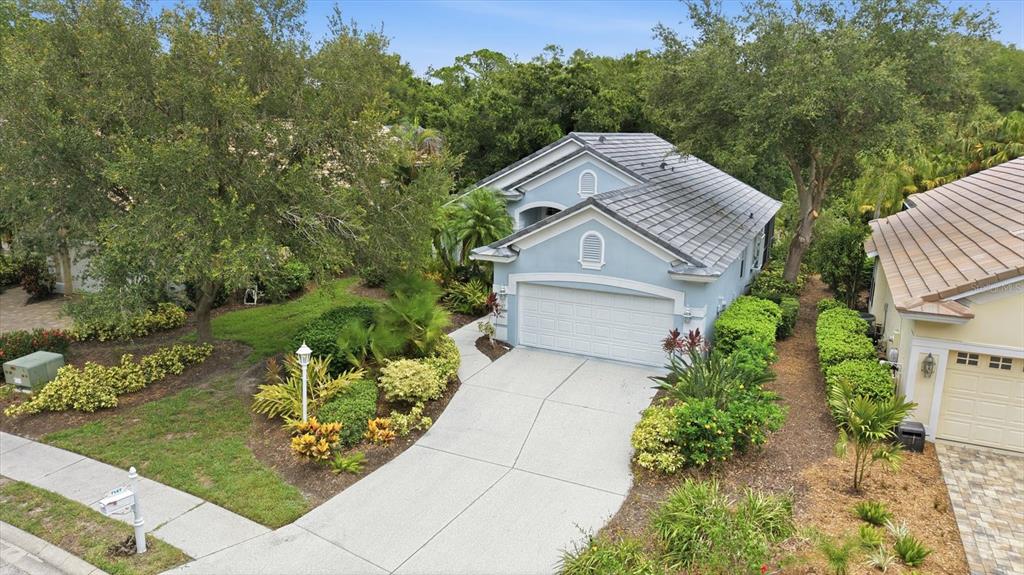An aerial view of a light blue house with a gray tile roof and driveway — 7147 PRESTWICK COURT, UNIVERSITY PARK, FL