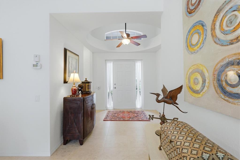 A bright entryway features a domed ceiling, a ceiling fan, tile flooring, and decorative art — 7147 PRESTWICK COURT, UNIVERSITY PARK, FL