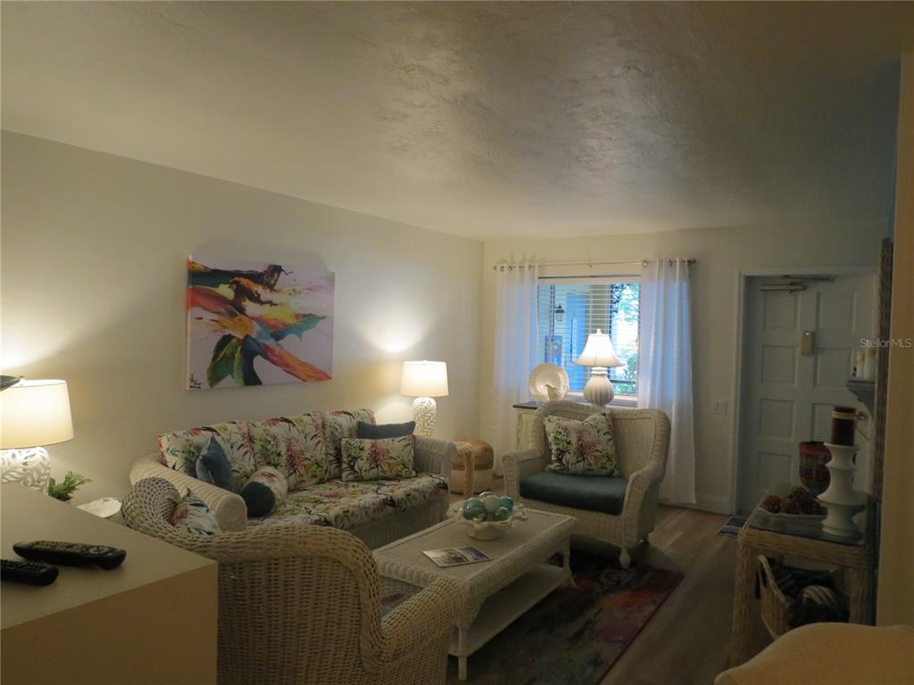 A living room features wicker furniture, a floral sofa, a coffee table, and a window — 615 S PALM AVENUE UNIT 4, SARASOTA, FL