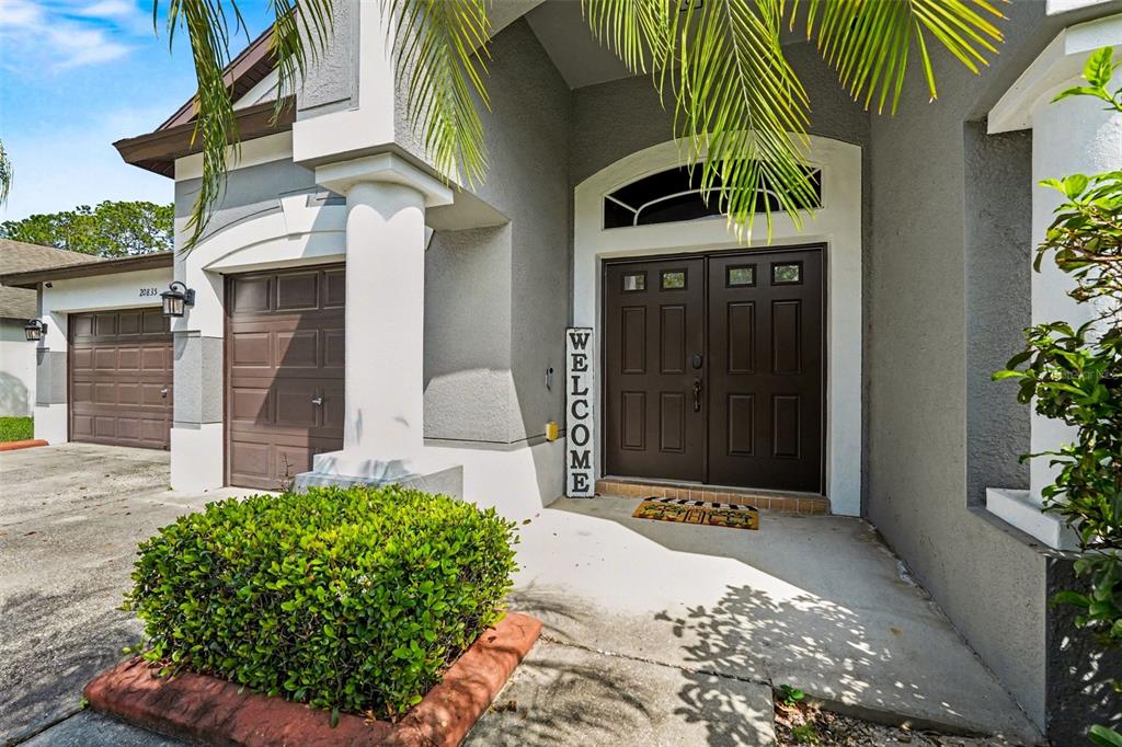 The exterior of a house features a brown double front door and a garage — 20835 RIVERFOREST DRIVE, LAND O LAKES, FL