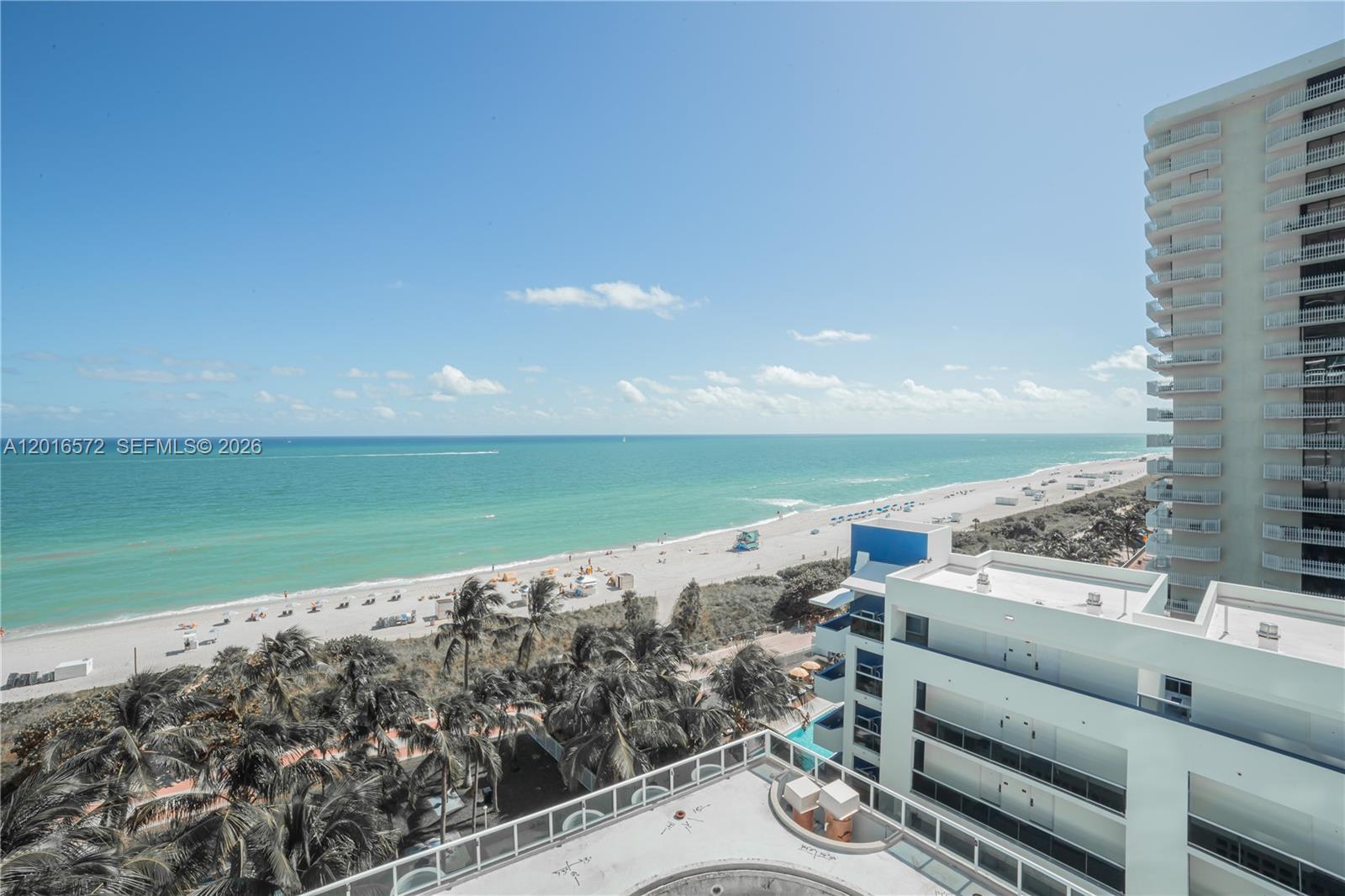 An elevated view overlooks a sandy beach, the ocean, and nearby high-rise buildings — 6301 Collins Ave # 1102, Miami Beach FL 33141, MIAMI BEACH, FL