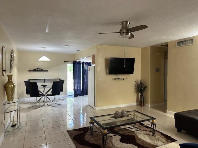 A living room and dining area with tile floors, a ceiling fan, and a wall-mounted television — 1511 SE 23rd Avenue # 1, Pompano Beach FL 33062, POMPANO BEACH, FL