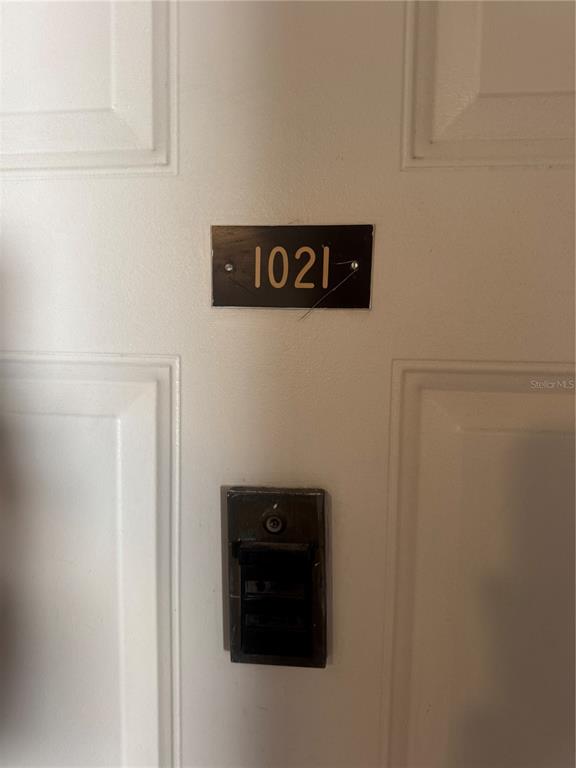 A white door features a black plaque with the number 1021 and a doorbell — 23465 HARBORVIEW ROAD UNIT 201, PUNTA GORDA, FL