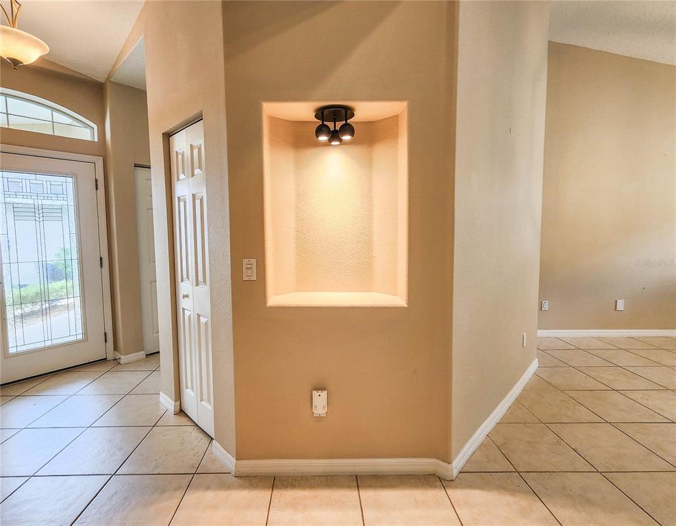A tiled entryway features a recessed wall niche with overhead lighting and a front door — 44 CROSSTIE COURT, PALM COAST, FL