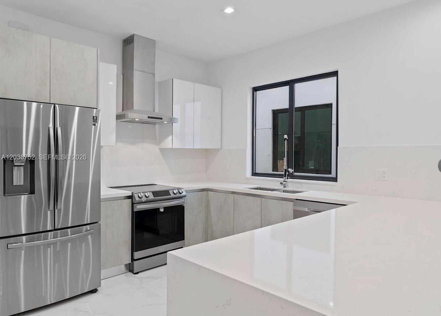 A modern kitchen features stainless steel appliances, white cabinetry, and light-colored stone countertops — 3374 Perry Frow Dr # B, Miami FL 33133, MIAMI, FL