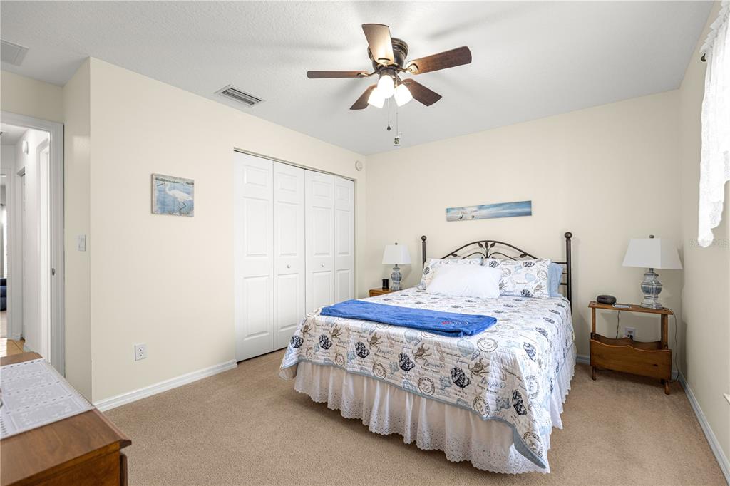 A living room with wood flooring, a floral sofa, a recliner, and a ceiling fan — 8721 SW 60 CIRCLE, OCALA, FL