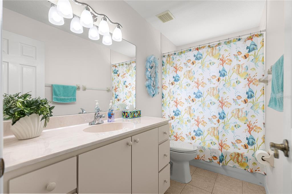 A view from an entryway into a living room with tile floors and a floral sofa — 8721 SW 60 CIRCLE, OCALA, FL