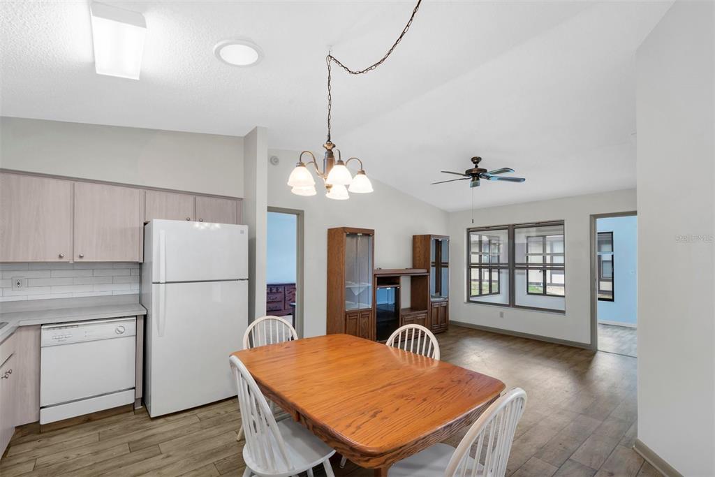 A kitchen and dining area featuring light wood cabinets, white appliances, and wood-look flooring — 37730 ALISSA DRIVE, ZEPHYRHILLS, FL