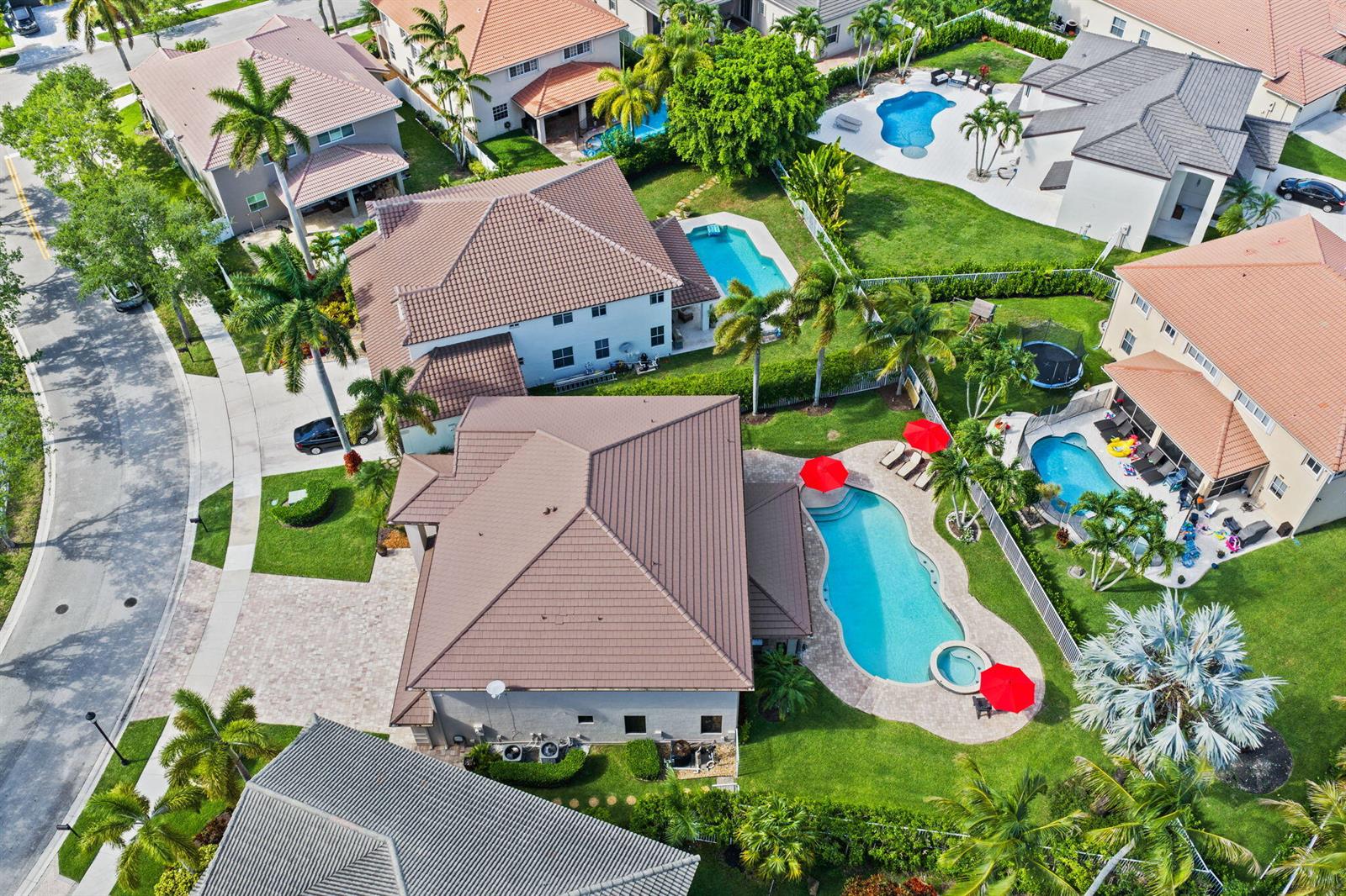 An aerial view shows several suburban houses with swimming pools and palm trees — 978 Greenwood Road, Weston FL 33327, WESTON, FL