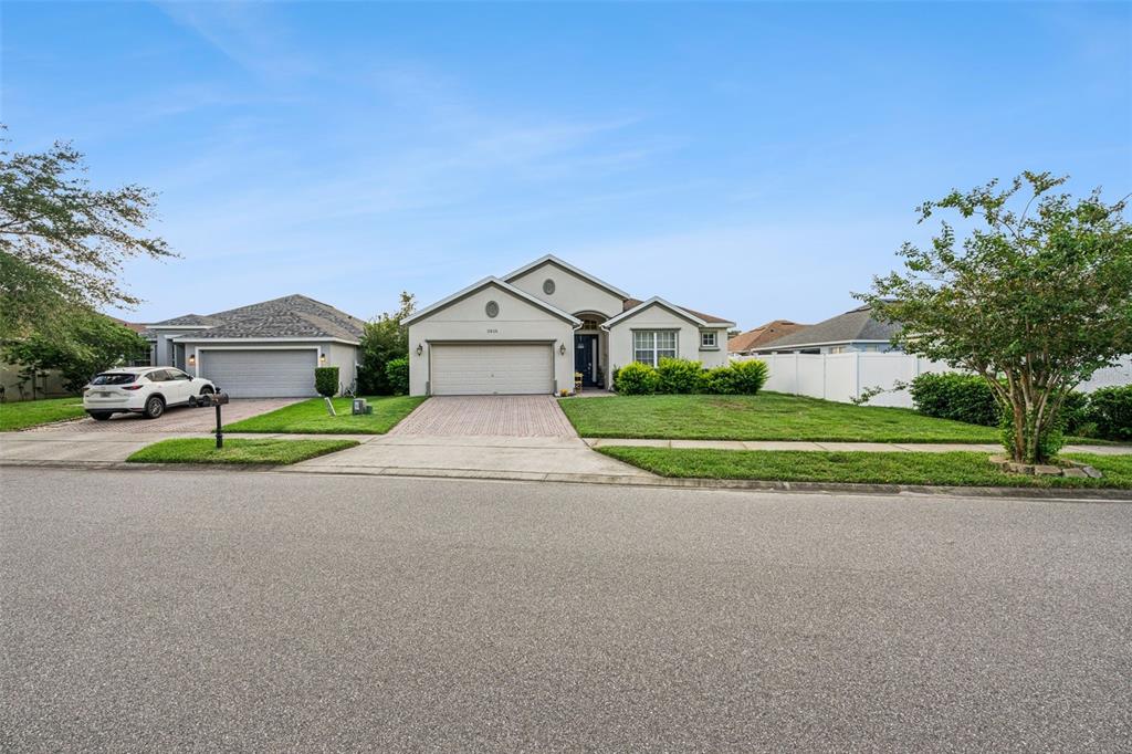 A single-story suburban house with a paved driveway, two-car garage, and a manicured front lawn — 3918 WATERSEND DRIVE, ORLANDO, FL