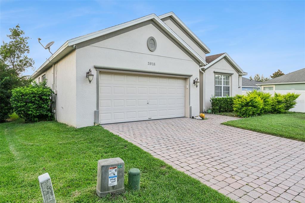 A single-story house with a white stucco exterior, a two-car garage, and a paved driveway — 3918 WATERSEND DRIVE, ORLANDO, FL