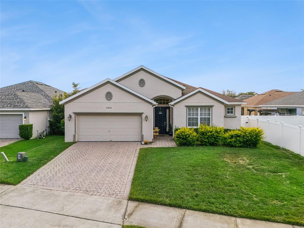 A single-story house with a beige stucco exterior, a two-car garage, and a paved driveway — 3918 WATERSEND DRIVE, ORLANDO, FL
