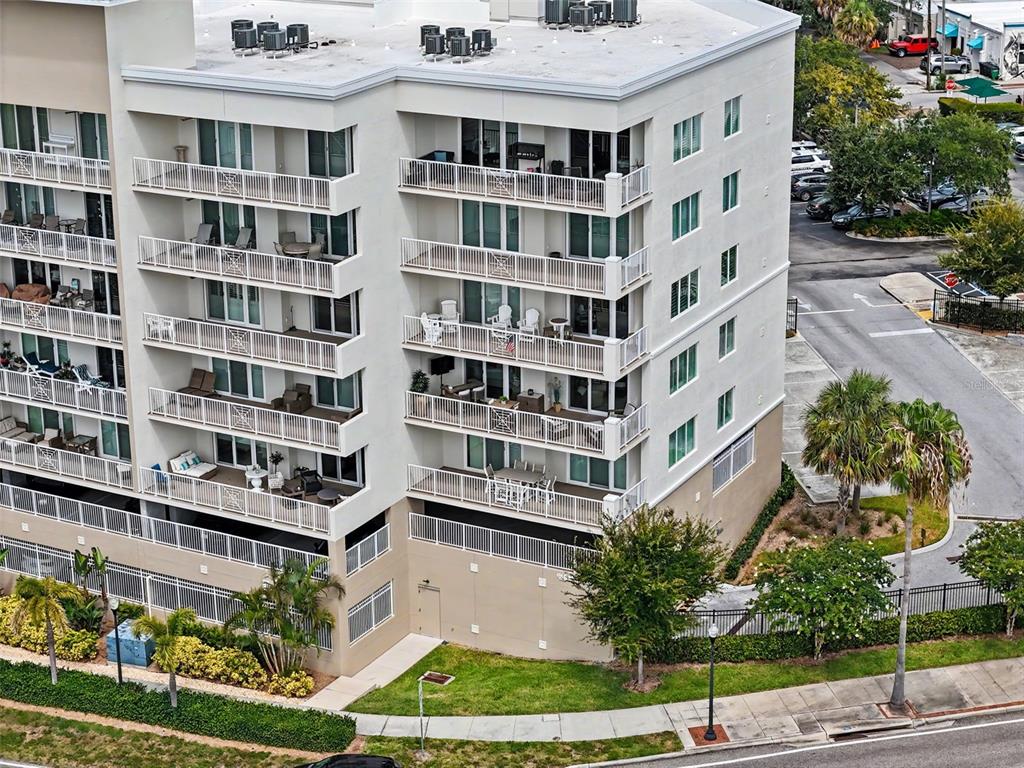 An aerial view of a multi-story apartment building with balconies and a parking lot — 101 S BAYSHORE BOULEVARD UNIT 49, SAFETY HARBOR, FL