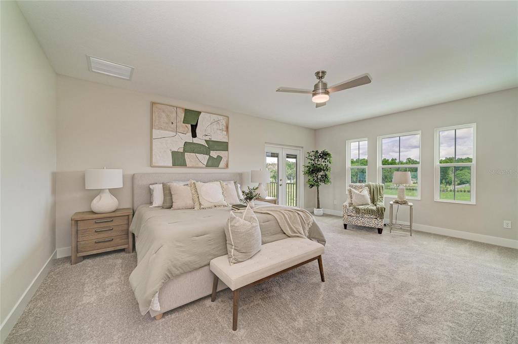 A spacious bedroom features a king-sized bed, neutral decor, carpeted floors, and large windows — 1132 BUCK CREEK COURT, BRANDON, FL