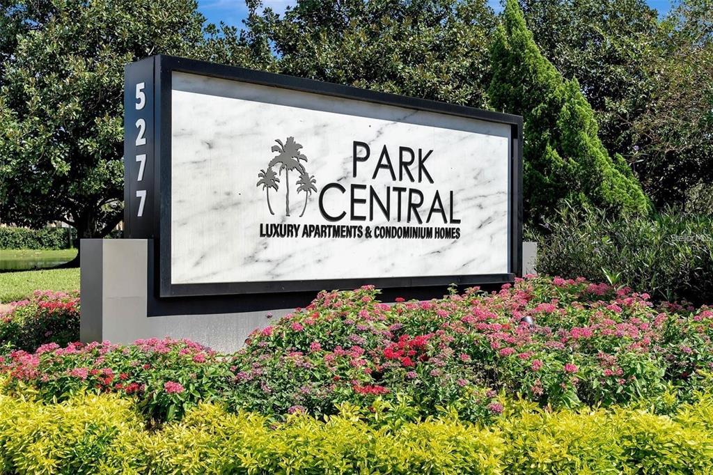 A sign for Park Central luxury apartments and condominium homes stands in a landscaped garden — 2336 MID TOWN TERRACE UNIT 932, ORLANDO, FL